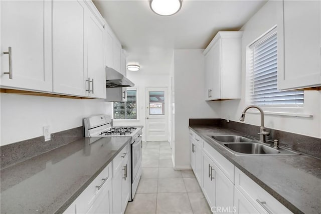 1510 E Idahome St, West Covina, CA 91791 - kitchen with white gas stove, ventilation hood, white cabinets, light tile patterned flooring, and dark stone countertops