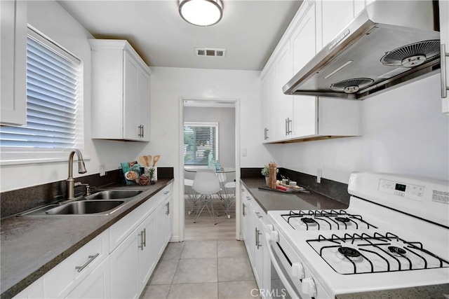 1510 E Idahome St, West Covina, CA 91791 - kitchen with gas range gas stove, range hood, dark countertops, white cabinetry, and light tile patterned floors