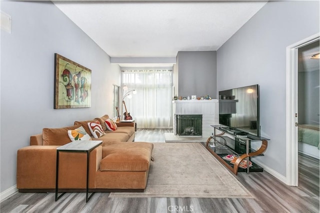 7800 Topanga Canyon Blvd Unit 324, Canoga Park, CA 91304 - living room featuring wood finished floors and a fireplace