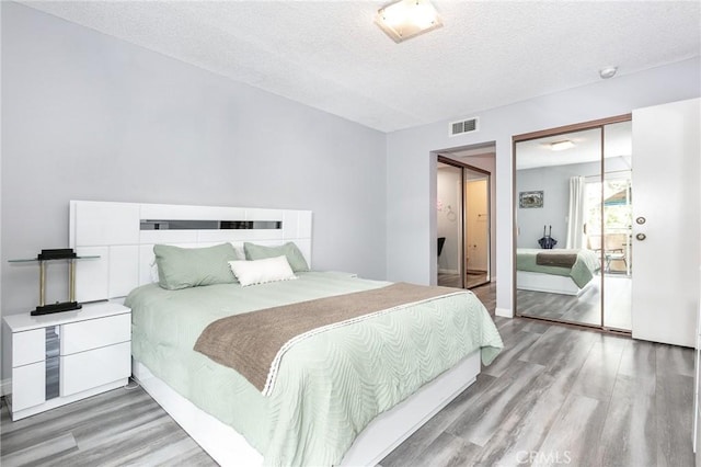 7800 Topanga Canyon Blvd Unit 324, Canoga Park, CA 91304 - bedroom with wood finished floors, a textured ceiling, and a closet