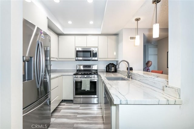 7800 Topanga Canyon Blvd Unit 324, Canoga Park, CA 91304 - kitchen featuring appliances with stainless steel finishes, light wood-style flooring, white cabinets, light stone counters, and recessed lighting