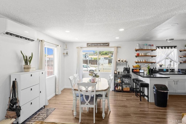 7023 Lisbon St, San Diego, CA 92114 - dining room with a textured ceiling, recessed lighting, light wood-style floors, and a wall mounted AC
