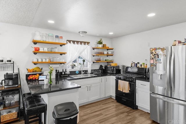 7023 Lisbon St, San Diego, CA 92114 - kitchen featuring stainless steel appliances, open shelves, dark countertops, light wood finished floors, and recessed lighting