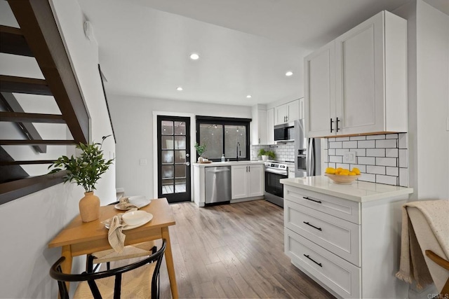 2282 Caminito Pescado Unit 44, San Diego, CA 92107 - kitchen with stainless steel appliances, tasteful backsplash, light wood-style flooring, light countertops, and recessed lighting