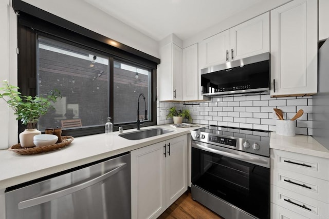 2282 Caminito Pescado Unit 44, San Diego, CA 92107 - kitchen with stainless steel appliances, white cabinets, light countertops, and decorative backsplash