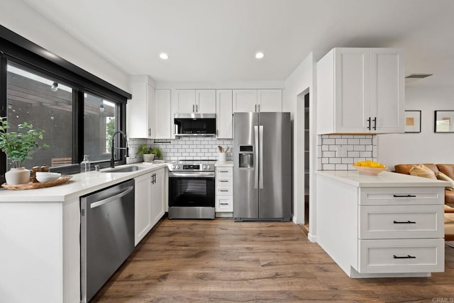 2282 Caminito Pescado Unit 44, San Diego, CA 92107 - kitchen with stainless steel appliances, tasteful backsplash, white cabinets, light countertops, and dark wood-style flooring