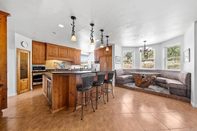 20202 Deerhorn Valley Rd, Jamul, CA 91935 - kitchen with appliances with stainless steel finishes, dark countertops, a chandelier, light tile patterned flooring, and open floor plan