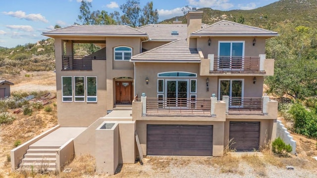 20202 Deerhorn Valley Rd, Jamul, CA 91935 - view of front of property featuring a balcony, stucco siding, an attached garage, a chimney, and driveway