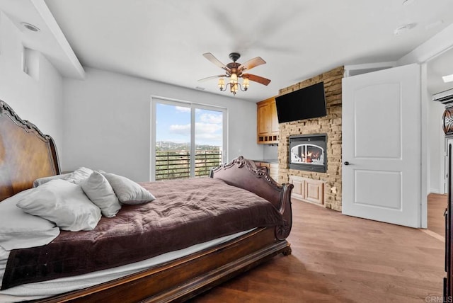 20202 Deerhorn Valley Rd, Jamul, CA 91935 - bedroom with a stone fireplace, light wood-style flooring, ceiling fan, and access to outside
