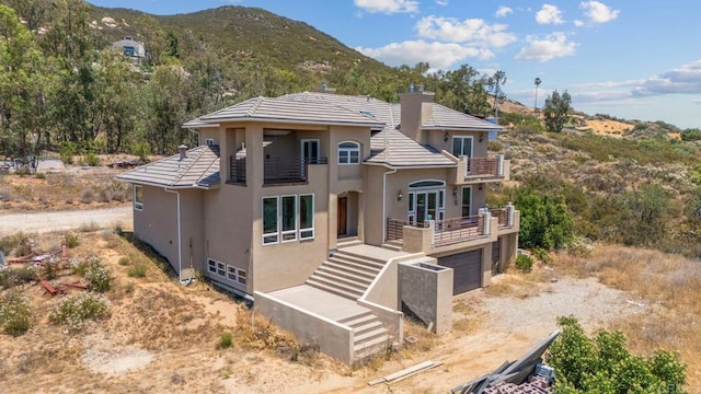 20202 Deerhorn Valley Rd, Jamul, CA 91935 - view of front of home with a balcony, stucco siding, a garage, and a chimney