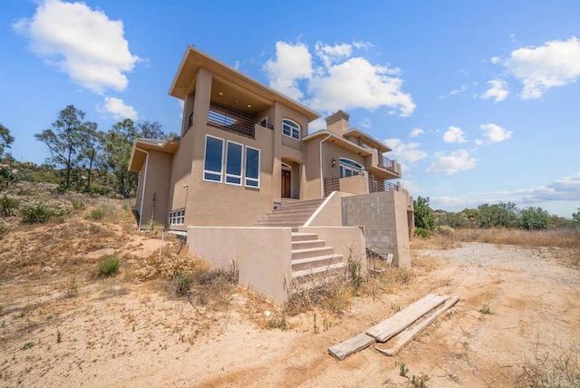 20202 Deerhorn Valley Rd, Jamul, CA 91935 - view of front of property with a balcony, stucco siding, stairs, and a chimney