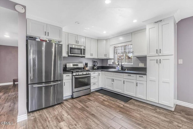 118 Everest St, Oxnard, CA 93030 - kitchen featuring stainless steel appliances, dark countertops, dark wood-type flooring, recessed lighting, and white cabinets