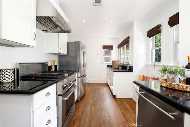 802 S Arroyo Blvd, Pasadena, CA 91105 - kitchen with exhaust hood, stainless steel appliances, dark countertops, dark wood-style floors, and white cabinetry