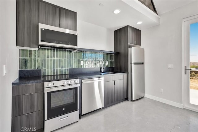 61850 Alta Mura Dr, Joshua Tree, CA 92252 - kitchen with stainless steel appliances, dark countertops, backsplash, modern cabinets, and recessed lighting