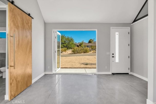 61850 Alta Mura Dr, Joshua Tree, CA 92252 - entrance foyer with finished concrete floors, a barn door, and vaulted ceiling