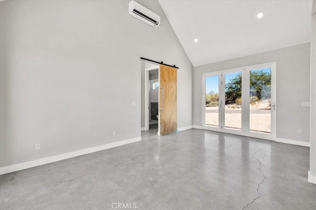 61850 Alta Mura Dr, Joshua Tree, CA 92252 - empty room featuring an AC wall unit, a barn door, concrete floors, high vaulted ceiling, and recessed lighting