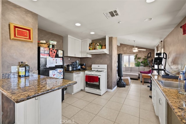 50802 280th St W, Lancaster, CA 93536 - kitchen with vaulted ceiling, white cabinets, white range with gas stovetop, light tile patterned floors, and a peninsula