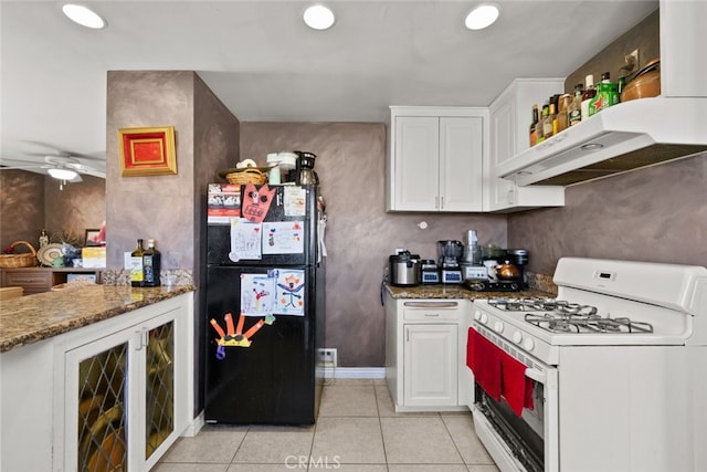 50802 280th St W, Lancaster, CA 93536 - kitchen with white gas range oven, freestanding refrigerator, light tile patterned floors, white cabinetry, and under cabinet range hood