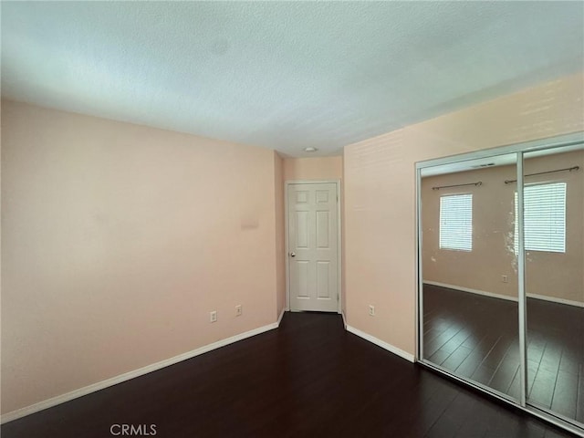 24112 Joshua Dr, Valencia, CA 91354 - unfurnished bedroom with dark wood-style floors, a textured ceiling, and a closet