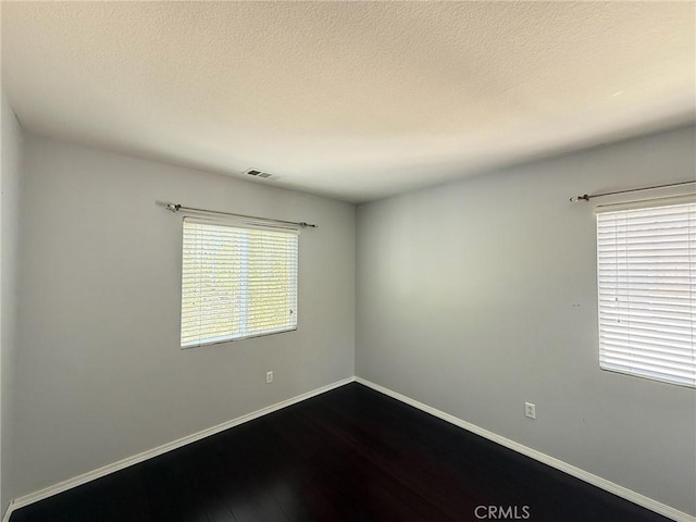 24112 Joshua Dr, Valencia, CA 91354 - unfurnished room with dark wood-type flooring and a textured ceiling