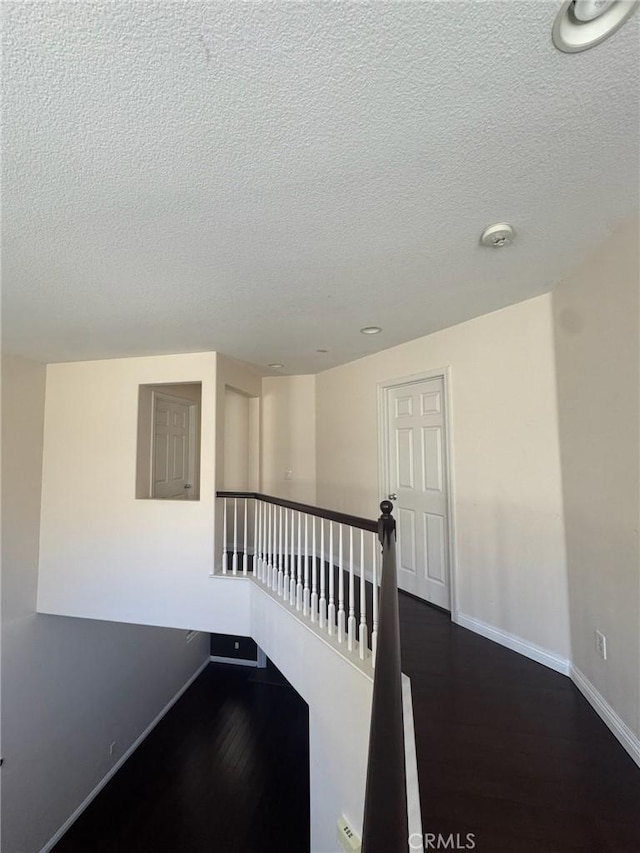 24112 Joshua Dr, Valencia, CA 91354 - stairway featuring a textured ceiling and wood finished floors
