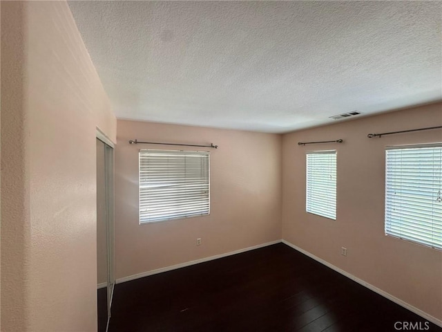 24112 Joshua Dr, Valencia, CA 91354 - unfurnished room featuring a textured ceiling and dark wood finished floors