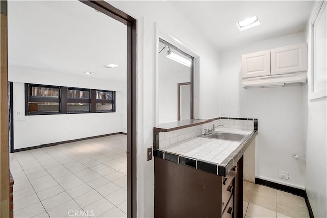 2511 W 5th St, Los Angeles, CA 90057 - kitchen with tile countertops, light tile patterned floors, white cabinetry, and backsplash