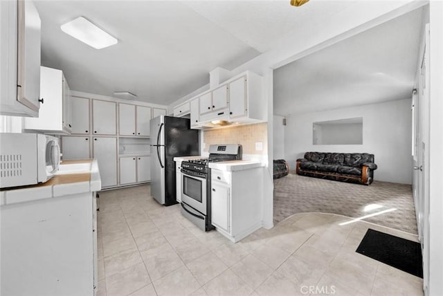 3648 Mira Pacific Dr, Oceanside, CA 92056 - kitchen featuring stainless steel appliances, light countertops, white cabinets, under cabinet range hood, and light tile patterned floors