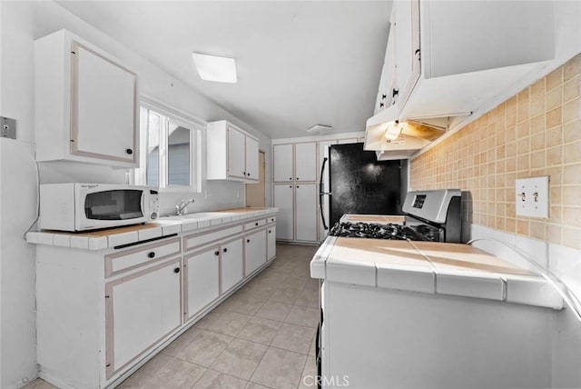 3648 Mira Pacific Dr, Oceanside, CA 92056 - kitchen featuring white microwave, tile countertops, backsplash, and white cabinets