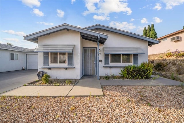 3648 Mira Pacific Dr, Oceanside, CA 92056 - view of front of home with an attached garage, stucco siding, driveway, and an AC wall unit