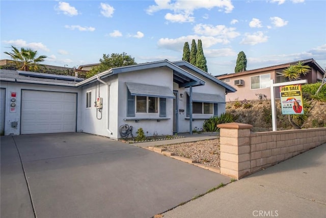 3648 Mira Pacific Dr, Oceanside, CA 92056 - view of front of house with concrete driveway, roof mounted solar panels, an attached garage, and stucco siding