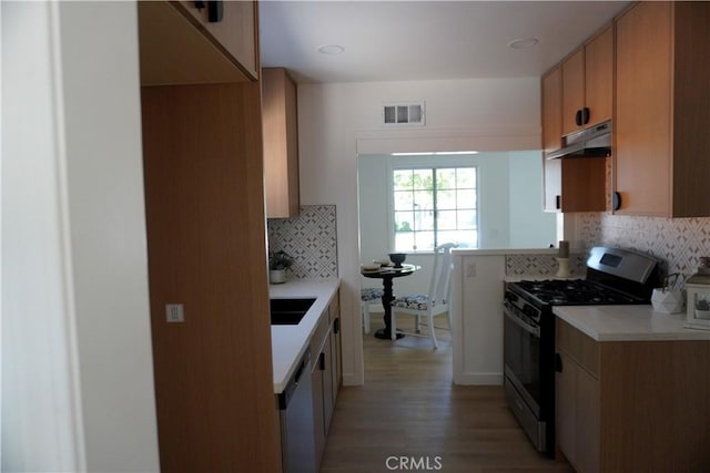 3565 Lashbrook Ave, Rosemead, CA 91770 - kitchen featuring stainless steel range with gas stovetop, under cabinet range hood, backsplash, light countertops, and light wood-type flooring
