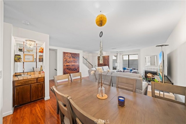 2608 W Grand Ave Unit B, Alhambra, CA 91801 - dining space with stairs, dark wood-style floors, and a tile fireplace