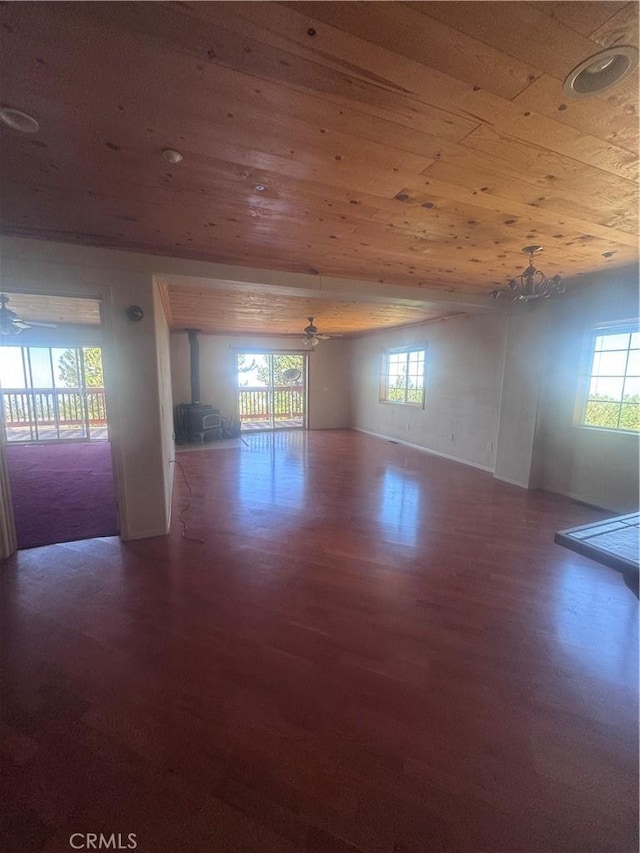 30134 Enchanted Way, Running Springs, CA 92382 - unfurnished room featuring wood finished floors, wooden ceiling, a wood stove, a chandelier, and healthy amount of natural light