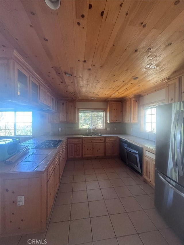 30134 Enchanted Way, Running Springs, CA 92382 - kitchen with freestanding refrigerator, wood ceiling, tile counters, light tile patterned floors, and healthy amount of natural light