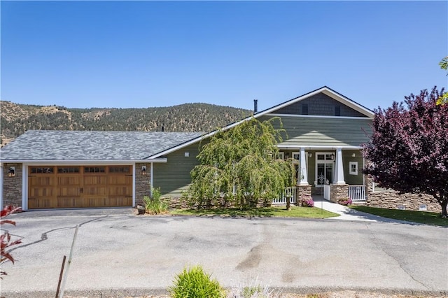 9401 Whispering Pines Rd, Frazier Park, CA 93225 - view of front facade featuring stone siding, driveway, an attached garage, and a porch