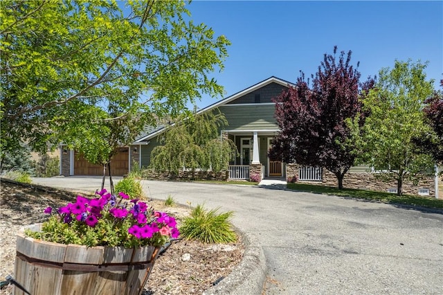 9401 Whispering Pines Rd, Frazier Park, CA 93225 - view of front facade featuring driveway, a porch, stone siding, and an attached garage