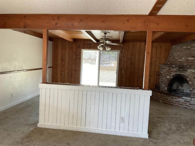 1110 E Alvarado St, Fallbrook, CA 92028 - unfurnished living room featuring carpet, beamed ceiling, a ceiling fan, wood walls, and a fireplace