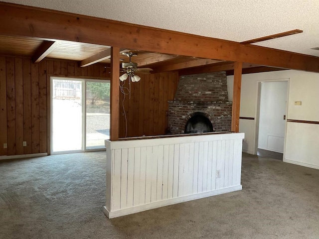 1110 E Alvarado St, Fallbrook, CA 92028 - unfurnished living room featuring beam ceiling, ceiling fan, carpet floors, wooden walls, and a fireplace