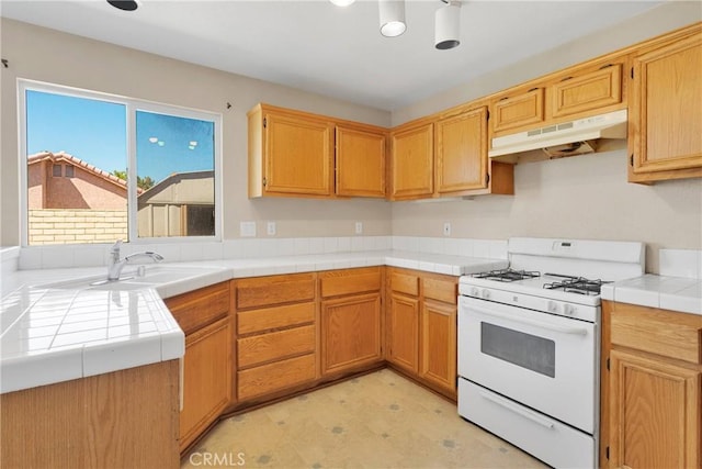 14094 Gray Ln, Victorville, CA 92394 - kitchen with gas range gas stove, under cabinet range hood, light floors, and tile counters
