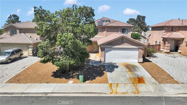 14094 Gray Ln, Victorville, CA 92394 - view of front of home with concrete driveway, a garage, stucco siding, a tile roof, and solar panels