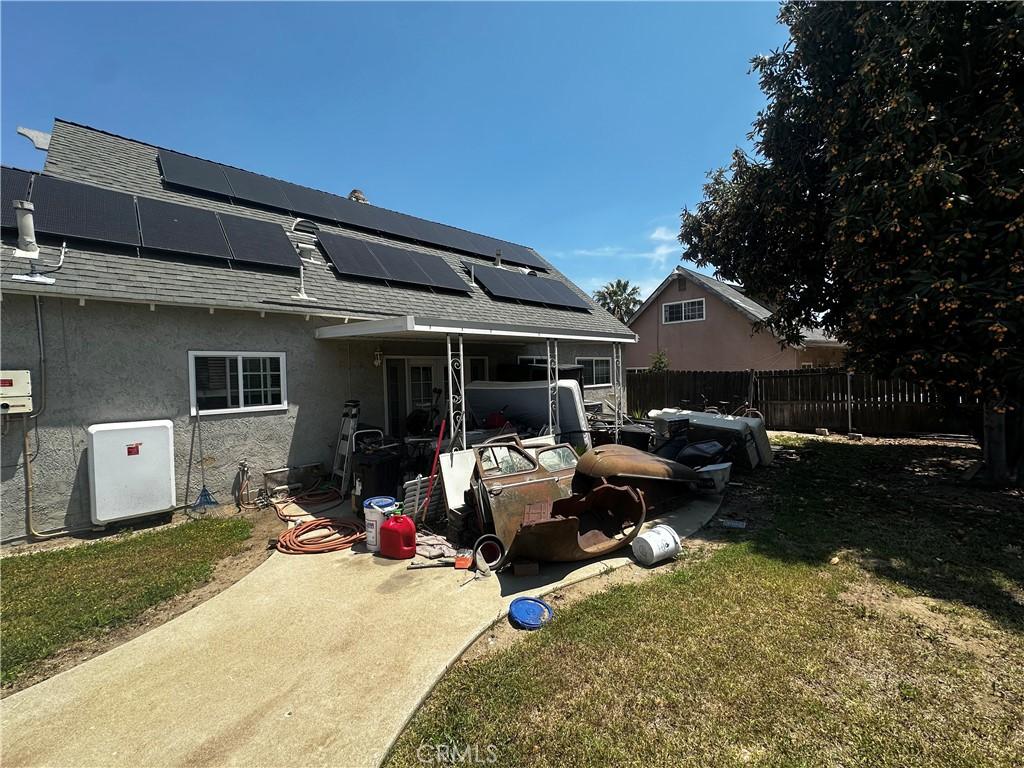 1374 N Primrose Ave, Rialto, CA 92376 - back of property with a shingled roof, stucco siding, and solar panels