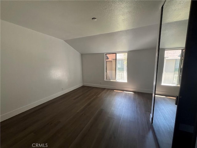 23240 Orange Ave Unit 8, Lake Forest, CA 92630 - unfurnished room with dark wood finished floors, vaulted ceiling, and a textured ceiling