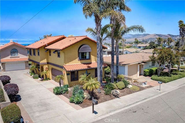 375 N 6th St, Grover Beach, CA 93433 - mediterranean / spanish home with stucco siding, a tiled roof, a garage, driveway, and a residential view