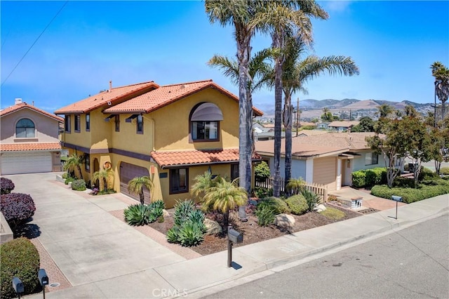 375 N 6th St, Grover Beach, CA 93433 - mediterranean / spanish-style home featuring an attached garage, stucco siding, concrete driveway, a tiled roof, and a mountain view