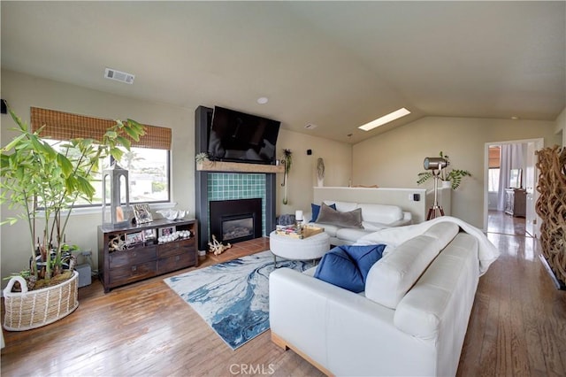 375 N 6th St, Grover Beach, CA 93433 - living room featuring wood finished floors, lofted ceiling, a tile fireplace, and a skylight