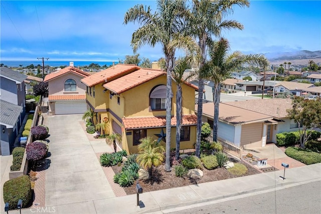 375 N 6th St, Grover Beach, CA 93433 - mediterranean / spanish house with a garage, driveway, stucco siding, a residential view, and a tiled roof