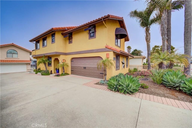 375 N 6th St, Grover Beach, CA 93433 - mediterranean / spanish house featuring an attached garage, driveway, stucco siding, and a tiled roof