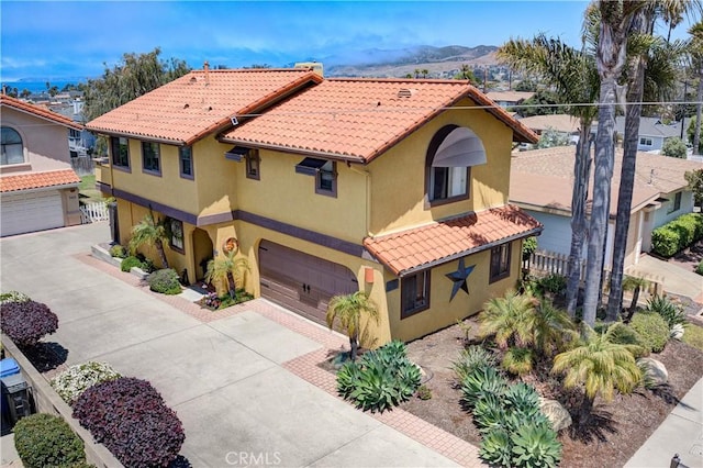 375 N 6th St, Grover Beach, CA 93433 - mediterranean / spanish-style home with an attached garage, stucco siding, concrete driveway, a mountain view, and a tile roof