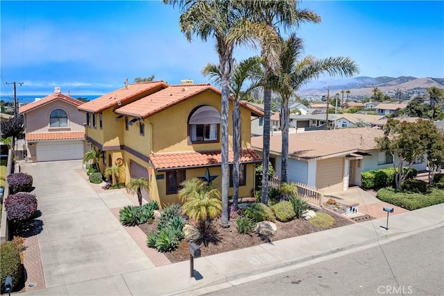 375 N 6th St, Grover Beach, CA 93433 - mediterranean / spanish home featuring concrete driveway, an attached garage, a tile roof, stucco siding, and a mountain view